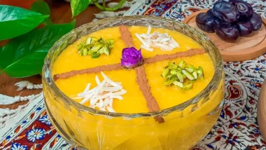 یک ظرف بزرگ شله زرد تزیین شده با دارچین و خلال پسته و خلال بادام و یک غنچه رز گل محمدی در وسط