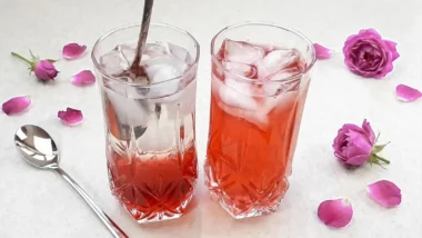 دو لیوان شربت گل محمدی یا گل سرخ خوشرنگ و خوش طعم حاوی تکه های یخ