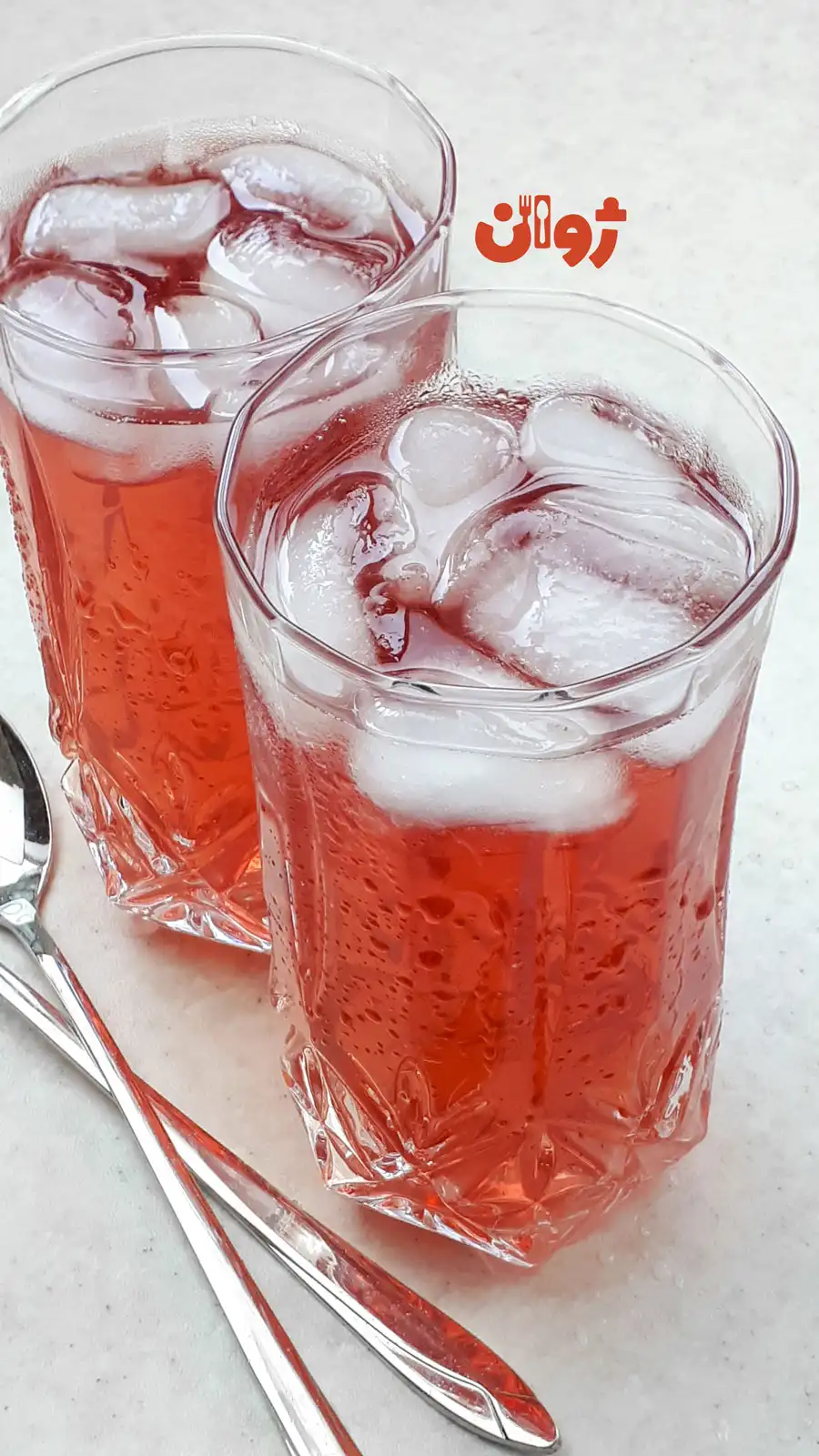 دو لیوان شربت گل محمدی یا گل سرخ خوشرنگ و خوش طعم حاوی تکه های یخ